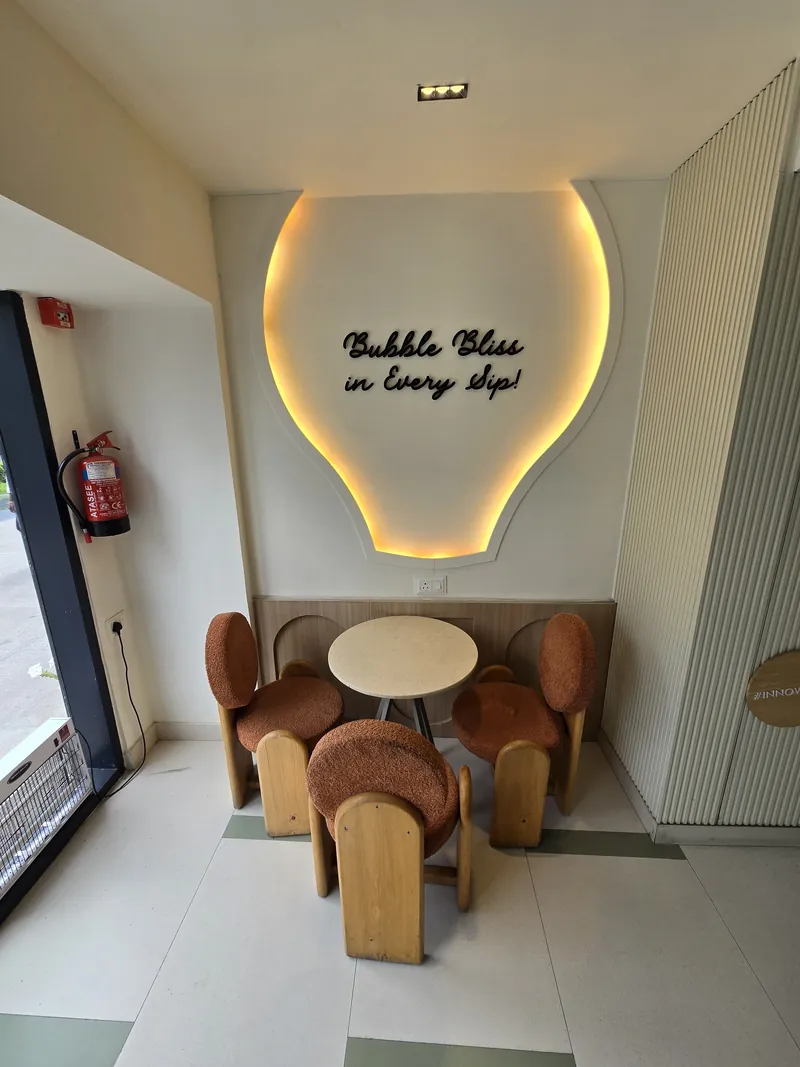 Terracotta chairs under the neon Bubble Bliss sign